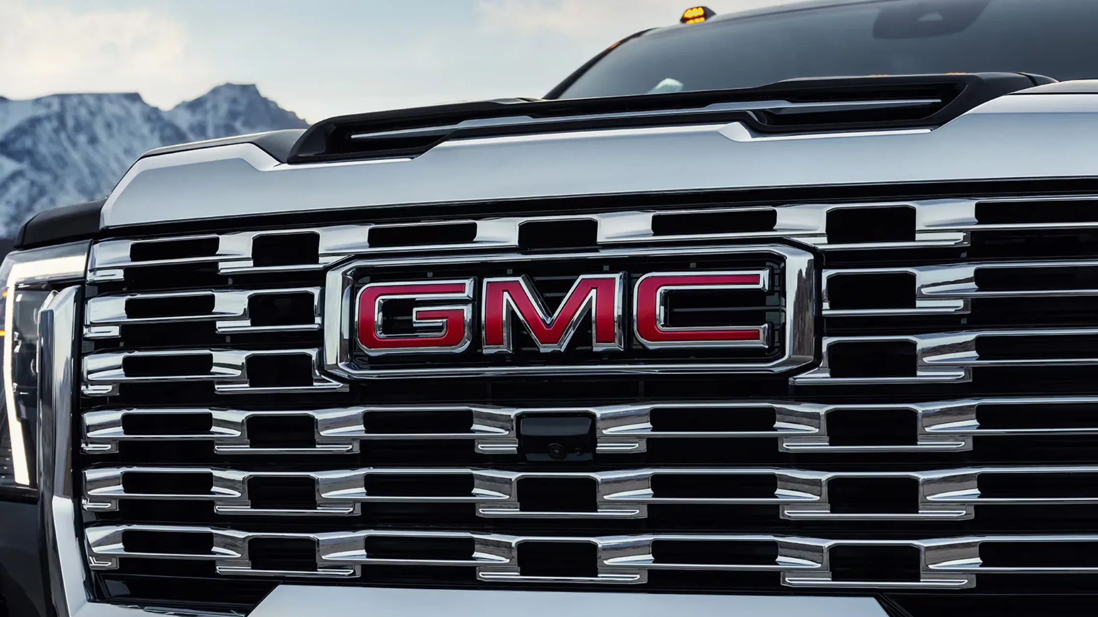 Front grille detail of 2025 GMC Sierra 3500 HD featuring bold red GMC logo and chrome accents.